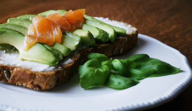 A plate of grilled salmon, quinoa, avocado, spinach and tomatoes representing a heart-healthy Mediterranean-style meal.